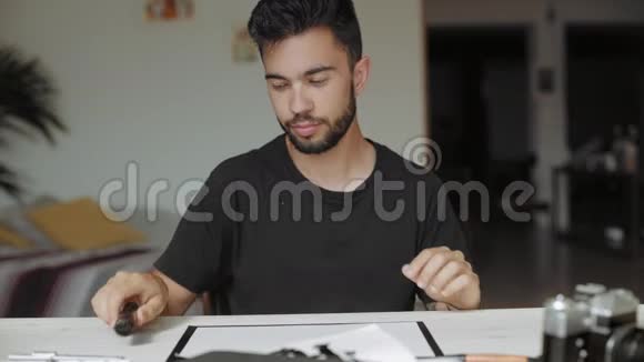 年轻漂亮的男性在白纸上写信息视频的预览图