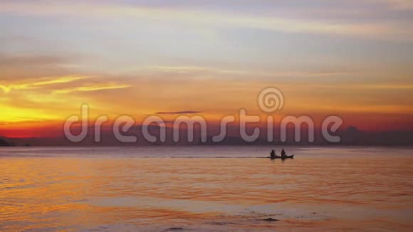 在令人惊叹的夕阳下划独木舟的夫妇剪影慢动作健康的生活方式运动3840x2160视频的预览图