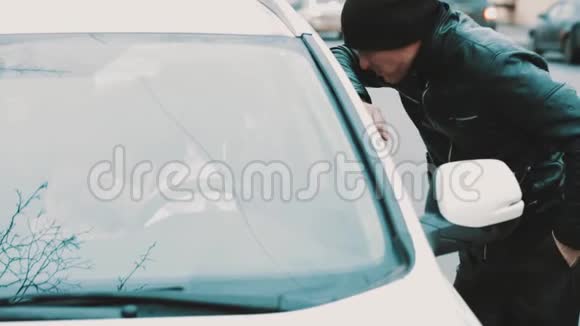 穿皮夹克的罪犯强迫女人坐在车里打开窗户视频的预览图