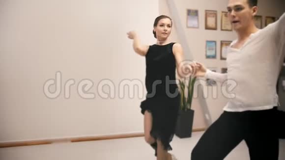 年轻迷人的男人和女人在工作室里穿着服装跳舞拉丁舞慢动作关门视频的预览图