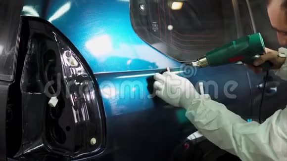 专家在车库表面光滑的机器粘贴乙烯基视频的预览图