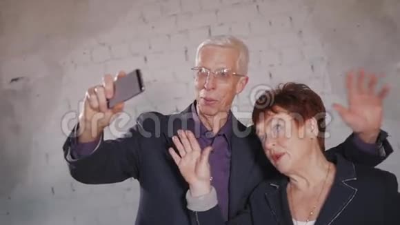 有智能手机的老年人在家自拍面带微笑视频的预览图