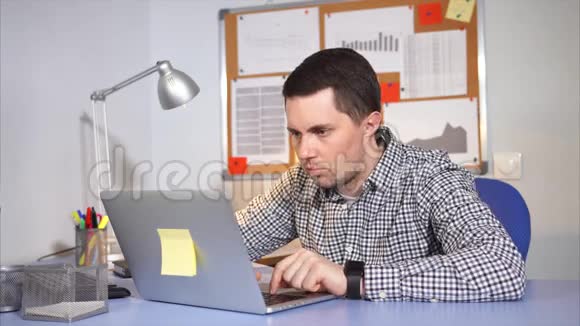 白种人在办公室里用笔记本电脑辛勤工作视频的预览图