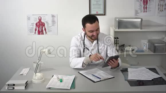 男医生在视频会议上使用平板电脑视频的预览图