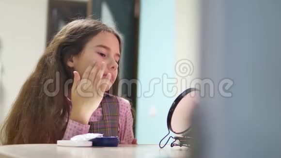 小女孩在室内女学生涂面霜少女脸上涂满了面霜视频的预览图