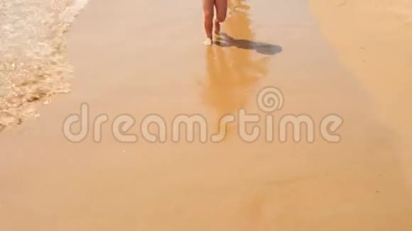 小女孩沿着潮湿的沙滩逃离妈妈视频的预览图