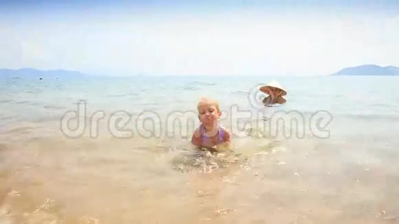 小女孩在海边对妈妈在草帽视频的预览图
