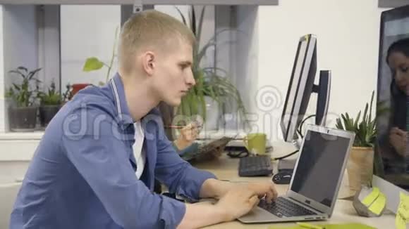 年轻的程序员用笔记本电脑工作视频的预览图