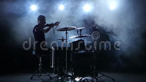 精力充沛的音乐家在鼓上演奏好音乐黑色烟熏背景剪影视频的预览图