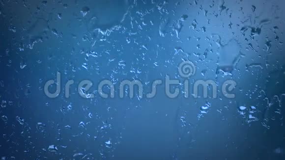 玻璃窗户上的蓝色雨水视频的预览图