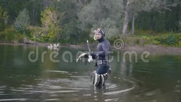 在森林里打猎后用水下渔夫的长矛把淡水鱼刺出水面视频的预览图