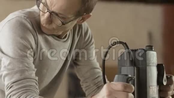 眼镜中的面木匠用插入路由器处理木板制造商视频的预览图