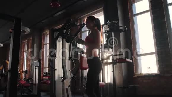瘦女孩正在健身房里喝瓶子里的水运动服运动员在训练中休息视频的预览图