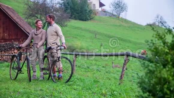 一对夫妇把自行车停在木栅栏上视频的预览图