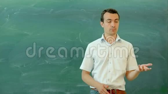 年轻的微笑老师站在清晰的粉笔旁边视频的预览图