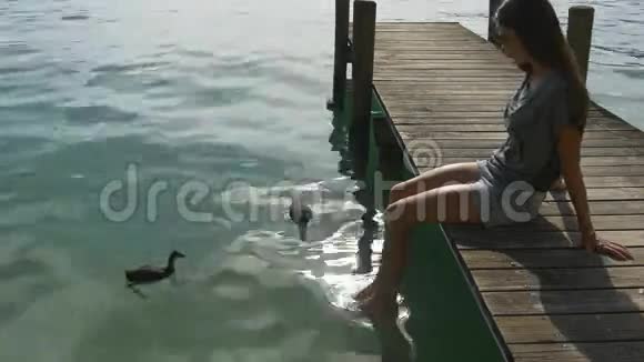 女人在干净明亮的水中玩鸭子视频的预览图