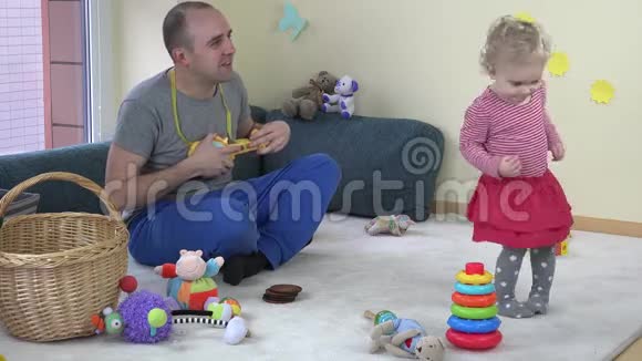 爸爸玩玩具吉他可爱的宝贝女儿跳舞4K视频的预览图