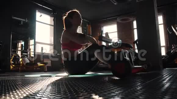 运动服的年轻女子在健身房锻炼腹肌有吸引力的女运动员从事腹部运动视频的预览图