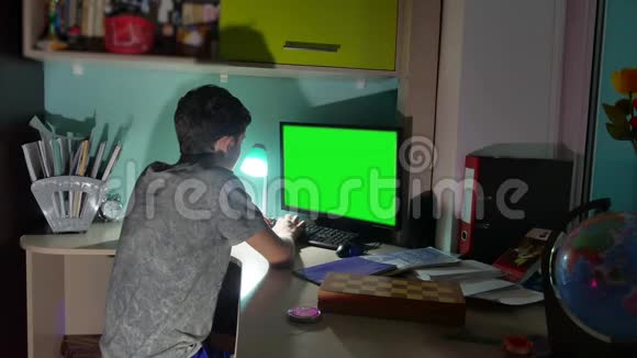 绿色钥匙室内青少年男孩玩电脑特写手游视频后坐青年学生考试视频的预览图