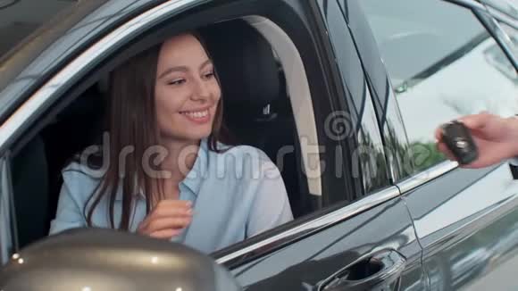 销售经理把钥匙交给坐在车里的女孩视频的预览图