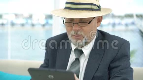 老人用平板电脑特写用手表看桌子4K视频的预览图