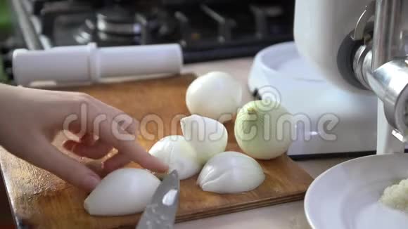 一个女人正在厨房的桌子上切一个白色的洋葱视频的预览图