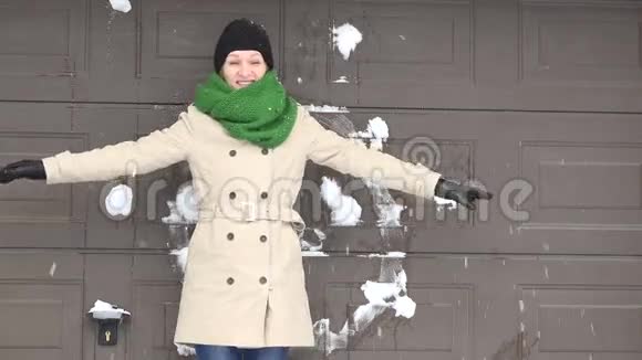 女人站在墙边有人朝她扔雪球视频的预览图