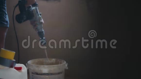 电动搅拌机将水泥混合在施工现场的桶中视频的预览图