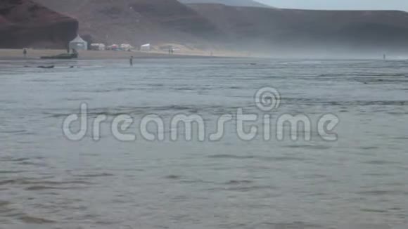 在摩洛哥的大西洋上捕鱼一个孤独的渔夫回来了在雾中用鱼竿在水面上游视频的预览图