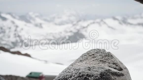 冒险家脚穿皮靴踩雪山景的石头视频的预览图