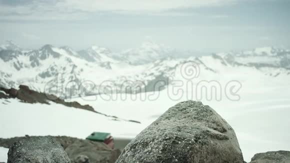 冒险家脚穿皮靴踩雪山景的岩石视频的预览图