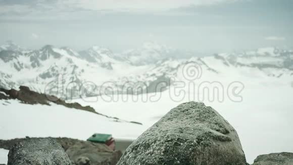 在雪山风景名胜区的岩石上踩着皮靴旅行的脚视频的预览图