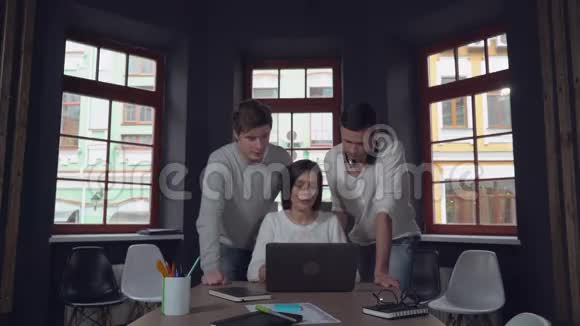 三个快乐的人看着电脑屏幕微笑视频的预览图