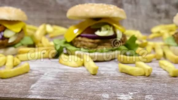 在美味汉堡旁边的木制背景上放大炸薯条视频的预览图