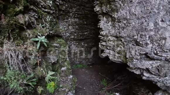 年轻女士徒步旅行背包穿越岩石或走出洞穴视频的预览图