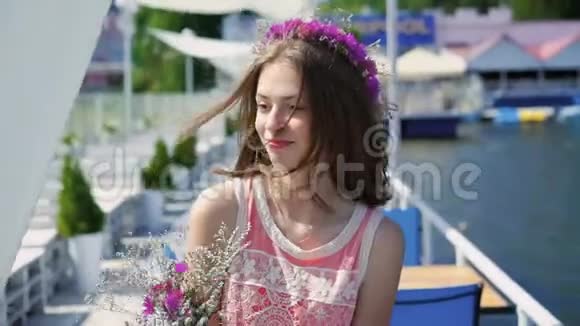 手里拿着野花的快乐女孩环顾四周在阳光明媚的风日里微笑着视频的预览图