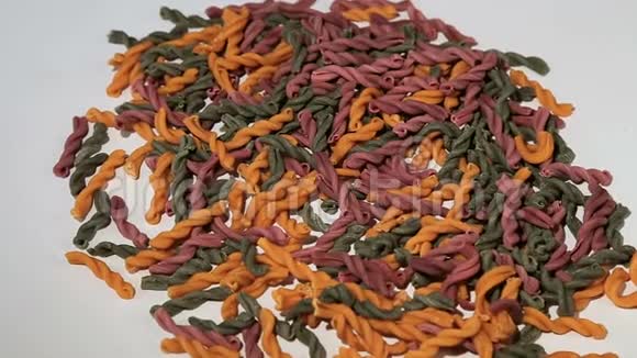 彩色螺旋面未煮熟的意大利面在白色背景上旋转美味的意大利杂菌视频的预览图
