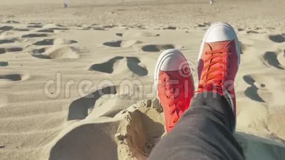 穿着红色运动鞋在蓝色海滩上放松的男人视频的预览图