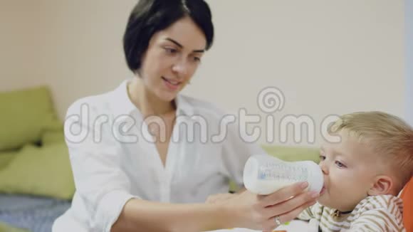 年轻的母亲给小儿子喂奶视频的预览图