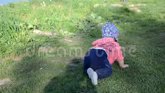 微笑可爱好玩的小女孩站在绿草上女孩蹒跚学步在湖边散步学会走路阳光明媚视频的预览图