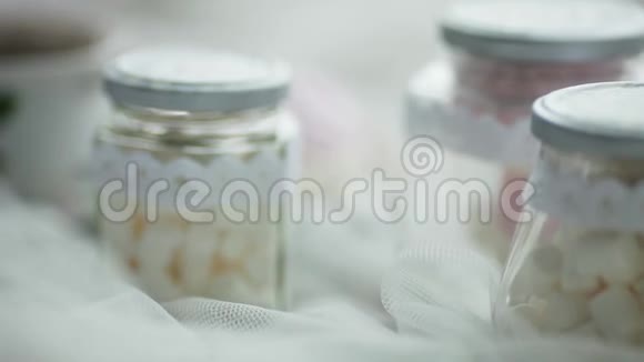棉花糖放在一个白色布上的玻璃罐子里特写视频的预览图