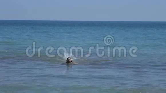 在阳光明媚的日子里女孩在海边游泳视频的预览图