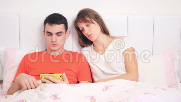 年轻夫妇正在看电话视频的预览图