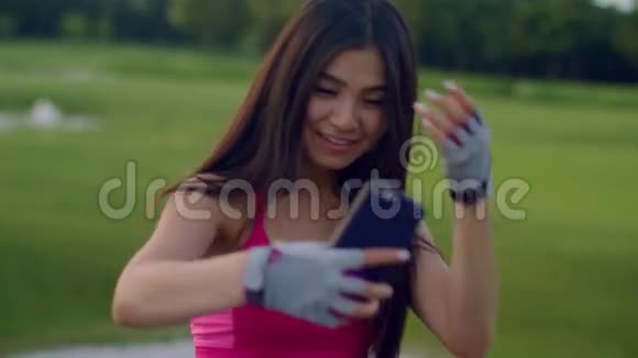 亚洲女孩在公园自拍运动女孩在公园打电话自拍视频的预览图