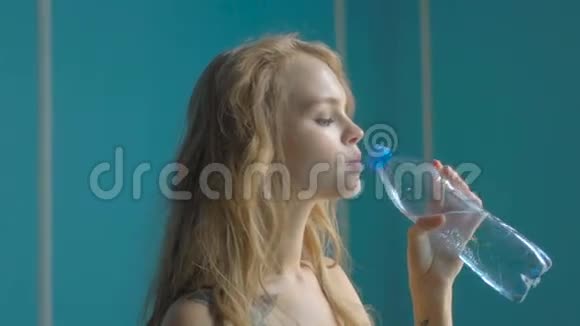 年轻女子喝着矿泉水瓶视频的预览图