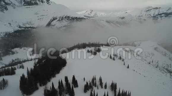 惊人的冬季景观4k空中拍摄的石山峰和雪山森林视频的预览图