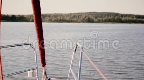 帆船的鼻部穿过湖面在阳光明媚的日子里迎风航行水上滑板车在船附近溅起波浪视频的预览图