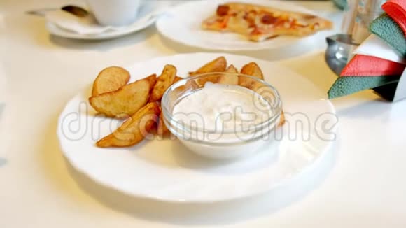 一个女人在咖啡馆里吃着炸土豆和酱汁视频的预览图