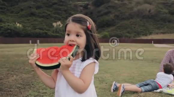 小女孩在户外吃西瓜片视频的预览图