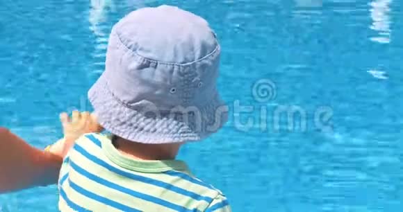 快乐的小男孩坐在游泳池附近视频的预览图